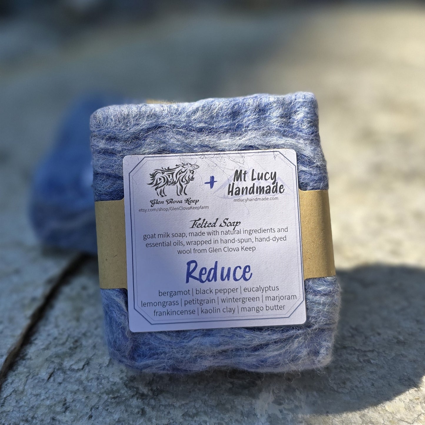 reduce square soap with blue felt and white label on a slate background