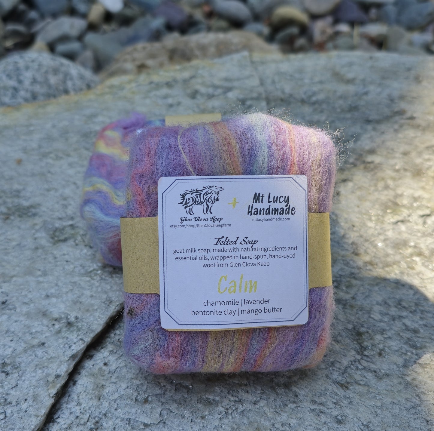 calm square soap wrapped in light pink and purple felt and white label on a slate background