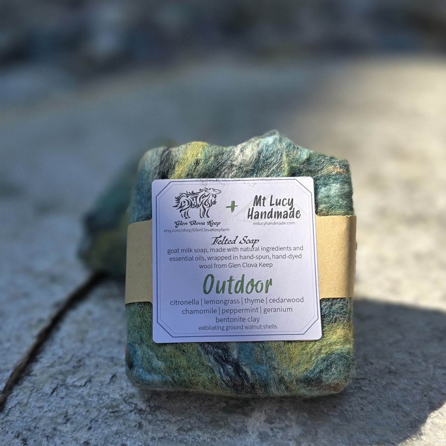 outdoor square soap with green felt and white label on a slate background